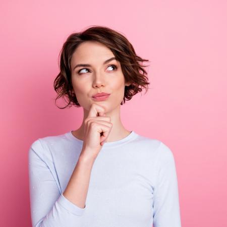 woman on pink background pondering