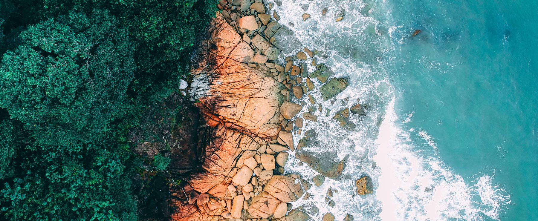 ocean meeting land drone shot